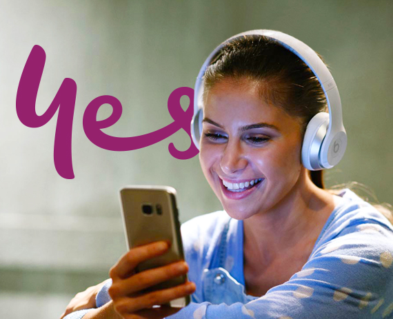 Girl with headphones on, smiling and watching entertainment on mobile phone - Optus Girl with headphones on, smiling and watching entertainment on mobile phone - Optus